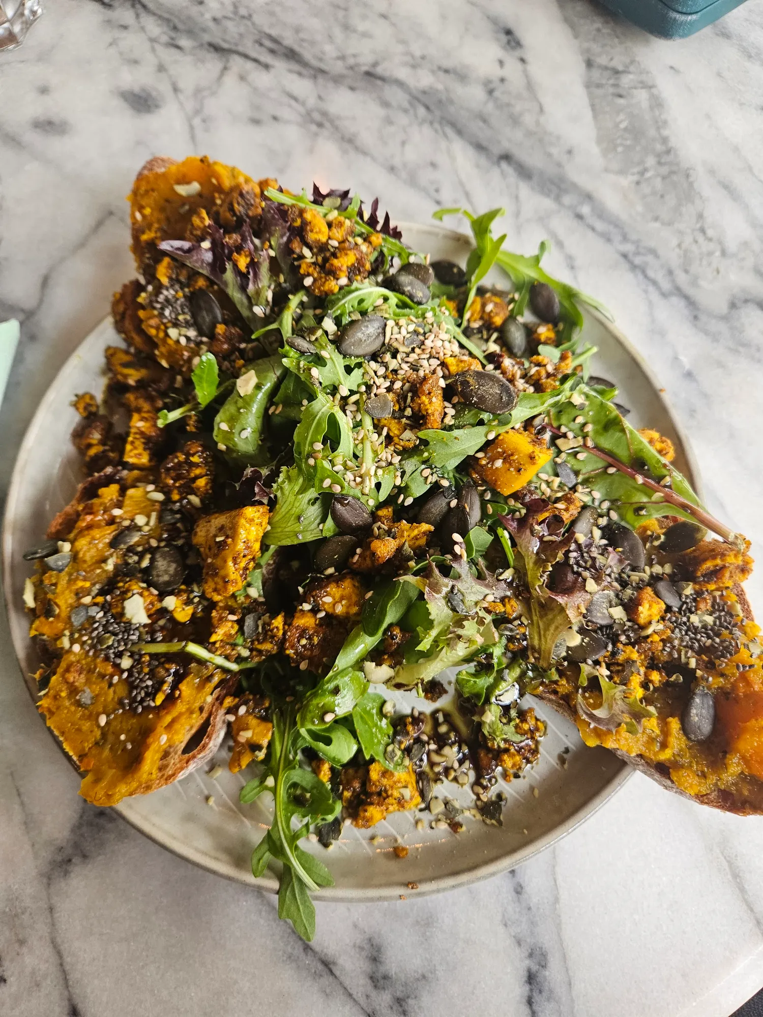 Tostada mit Hokkaido-Kürbis, Kernen und Salat auf Marmor